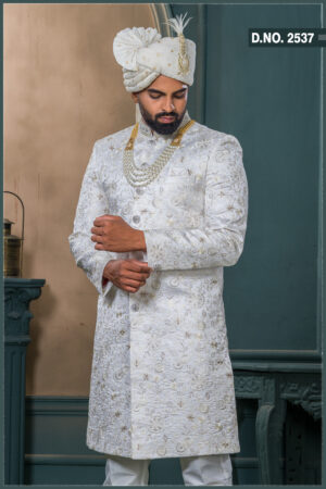 Ivory silk sherwani with golden thread and pearl embroidery, paired with an ivory turban featuring feather detailing and layered pearl mala.