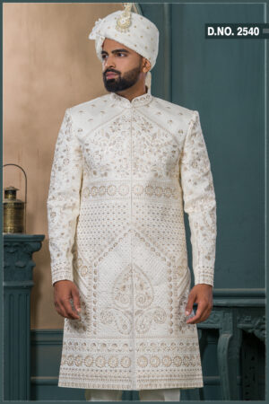 Ivory sherwani with intricate resham and sequin embroidery in floral and geometric patterns, paired with an ivory turban featuring pearl and feather embellishment.